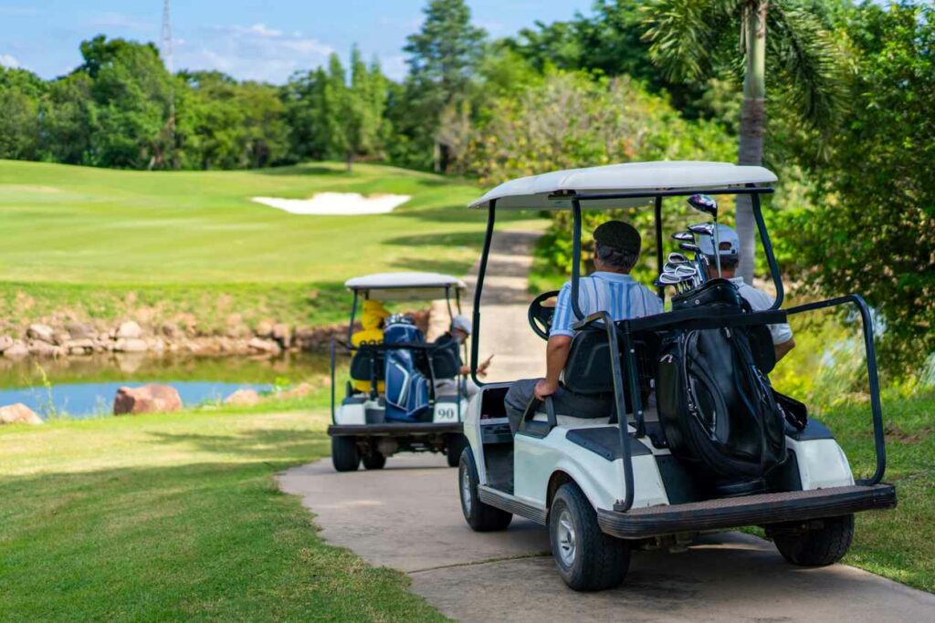 A few golfers traveling on golf carts.
