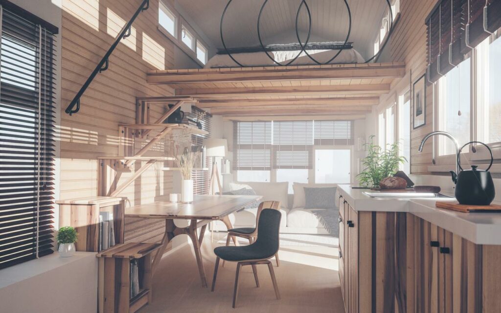 The rustic interior of a tiny house living room and kitchen with a modern overhead loft.