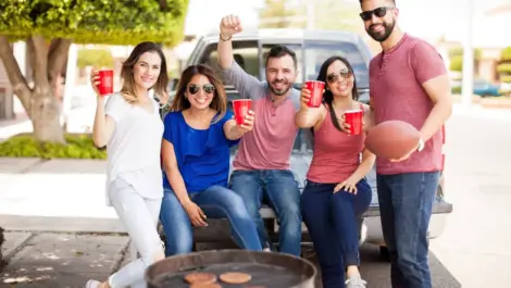 A group of tailgaters enjoying each other's company.