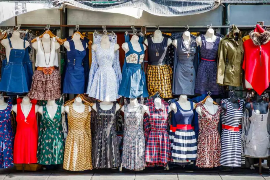 Vintage summer dresses hanging on display at a flea market. 