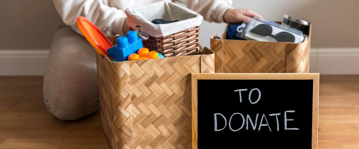 A woman packs bins of various household items to donate.