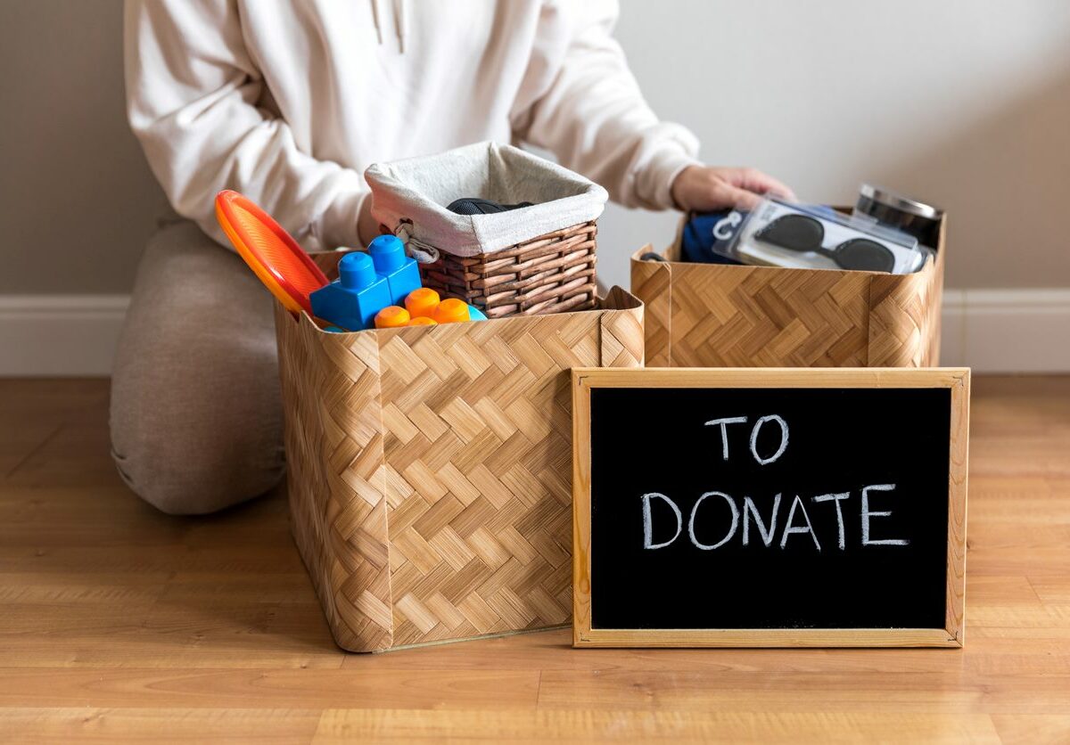 A woman packs bins of various household items to donate.