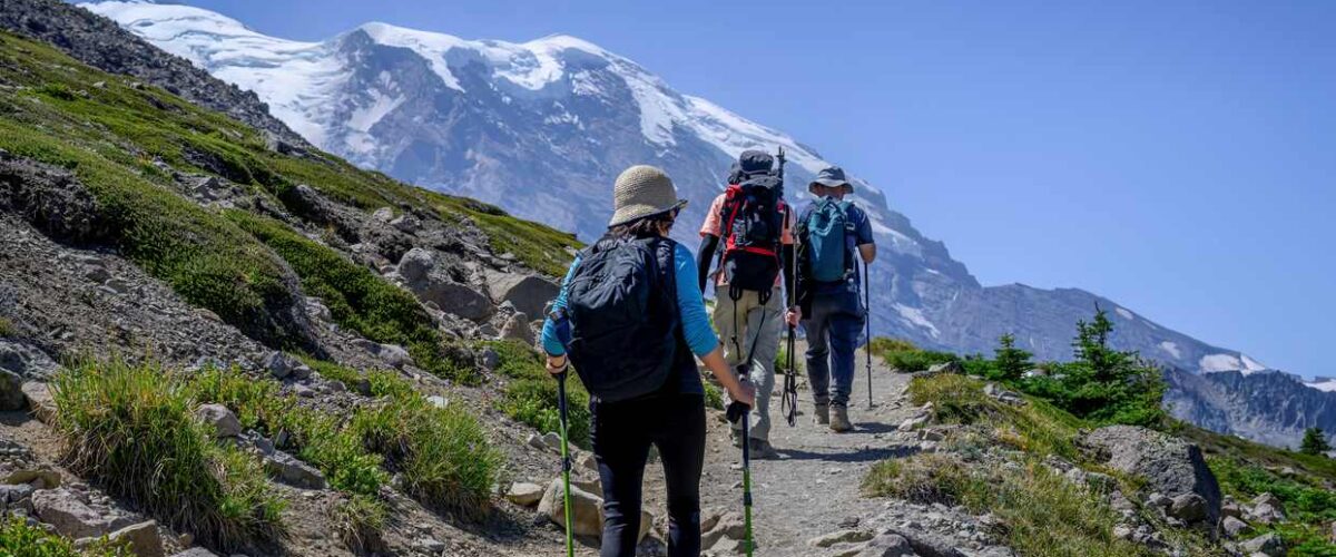 Three people hiking a mountain trail in Washington State.