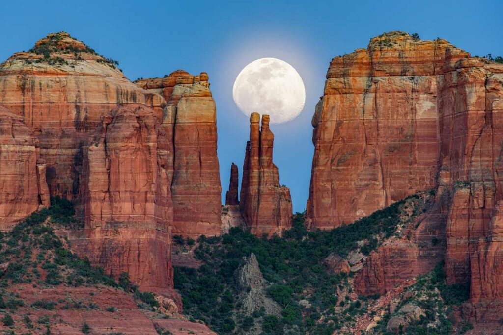 The moon rises behind Cathedral Rock in Sedona, AZ. 