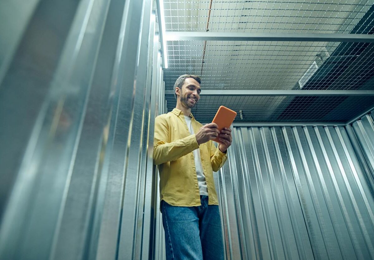 A man using a tablet in a smart storage unit, showing smart storage access in action.