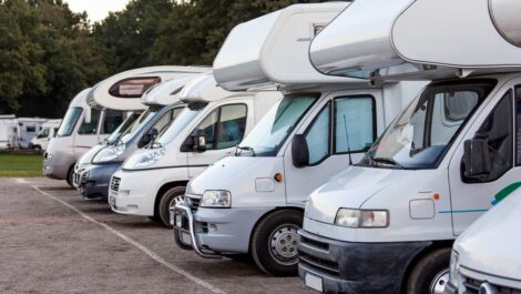 Multiple RVs parked in an organized outdoor storage lot.